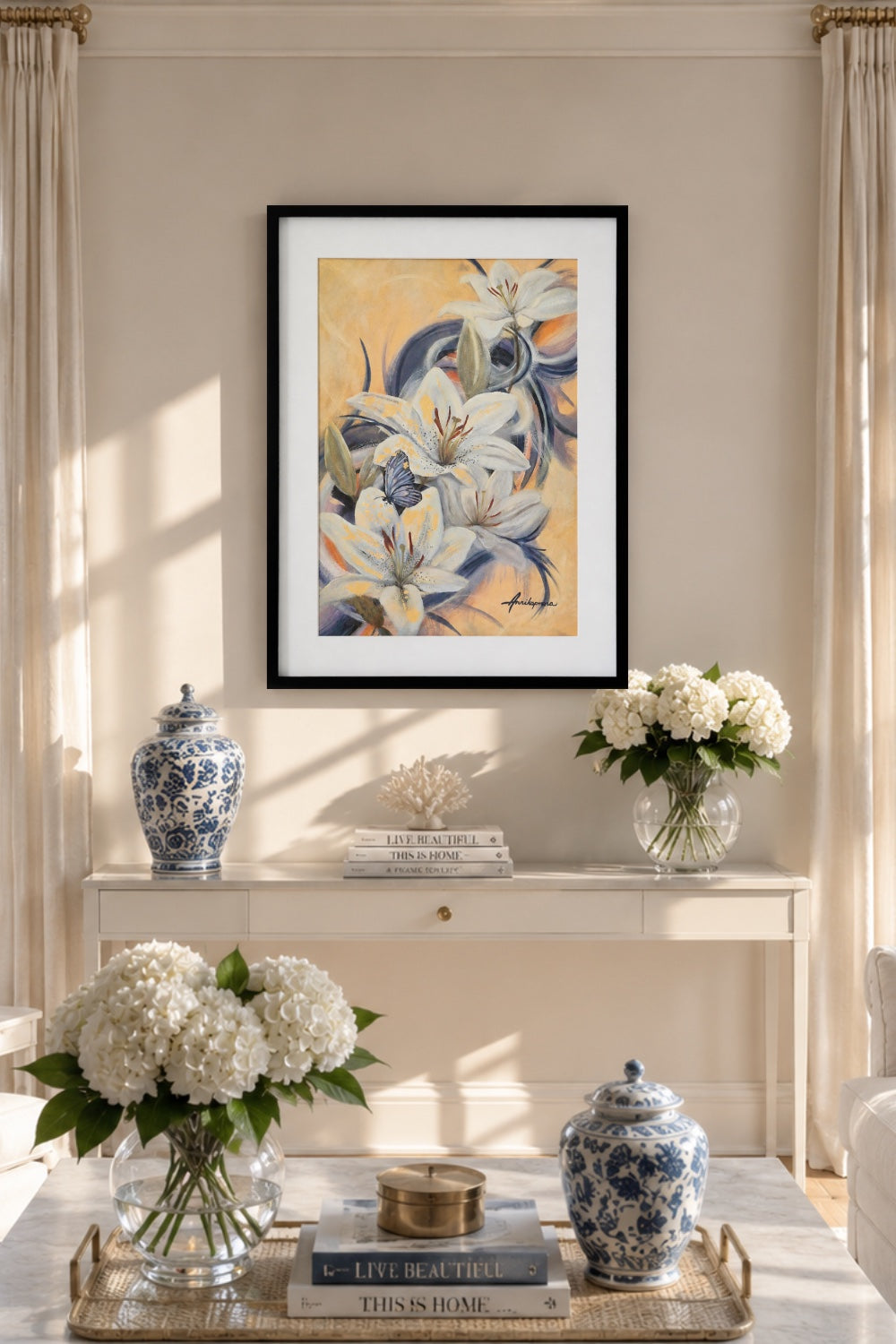 "Revealing the Gold Within — original painting by Annikaprana displayed in a black wood frame with white passepartout in a bright Scandinavian interior, white lilies and butterfly with Gold Metal Leaf details, Mixed Media Acrylic and Oil on Fabriano paper"