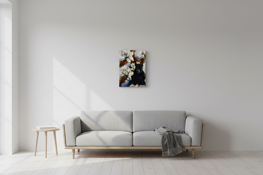 Feeling Small in a Big World — Canvas Print by Annikaprana, displayed at realistic scale on a white wall in a Scandinavian living room. Black bear with white magnolia flowers, giclée print on canvas with black 4 cm gallery wrap, 13×16″ (33×40 cm).
