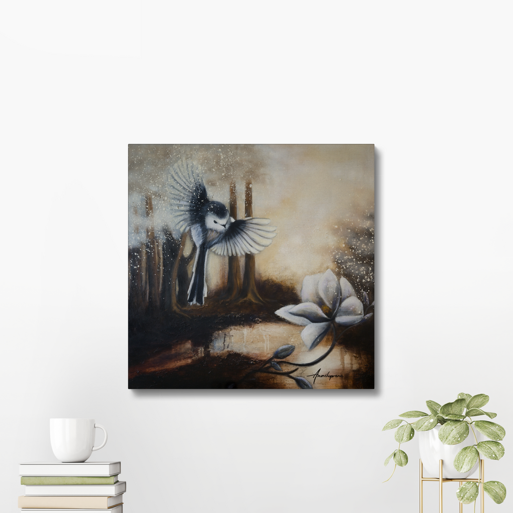 Sunshine After Rain 2026 — Canvas Print by Annikaprana. A long-tailed tit in flight above a white magnolia in a misty golden forest. Displayed on a white wall with a coffee cup and plant. Giclée on canvas, black 4 cm gallery wrap, ready to hang.