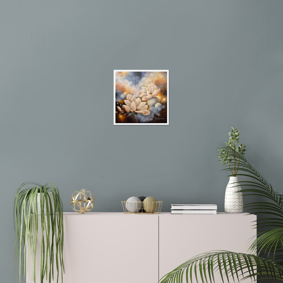 Flourishing in the Light — Fine Art Print by Annikaprana. Luminous white magnolia blossoms emerging from golden clouds against a deep, atmospheric background. Giclée on Hahnemühle German Etching 310gsm, white border, 12×12″ (≈30×30 cm). Displayed on a dusty blue wall above a blush sideboard in a Scandinavian living room.